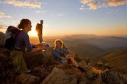 tourists in mountains at sunset