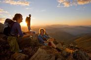 tourists in mountains at sunset