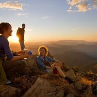 tourists in mountains at sunset